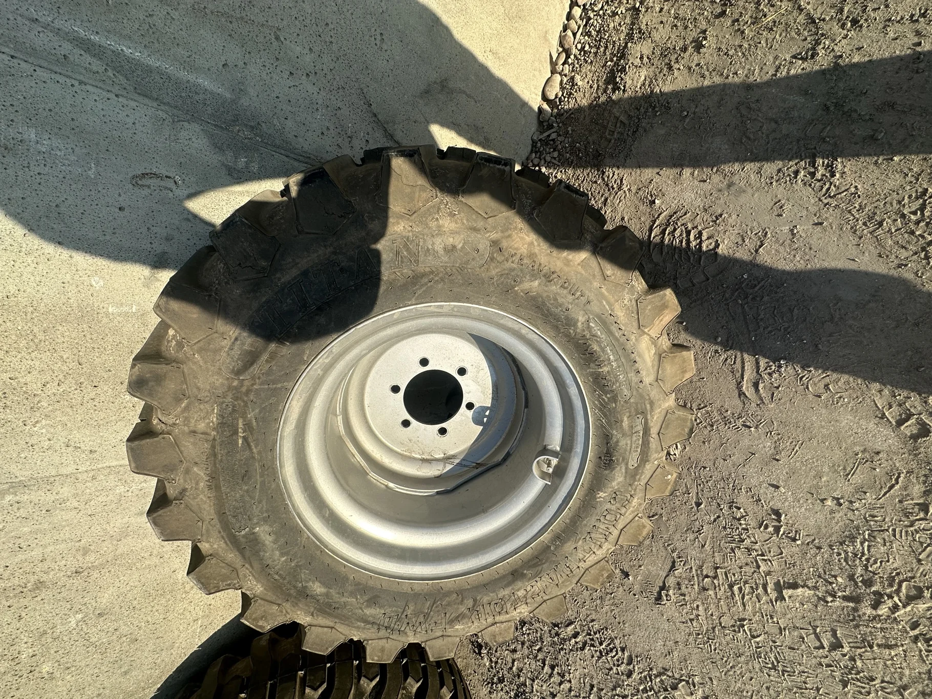 USED 12-16.5 Titan Trac Loader NHS C(6Ply) TL 95% on a 9.75 X 16.5 Silver Mist 6 Bolt Imp Wheel